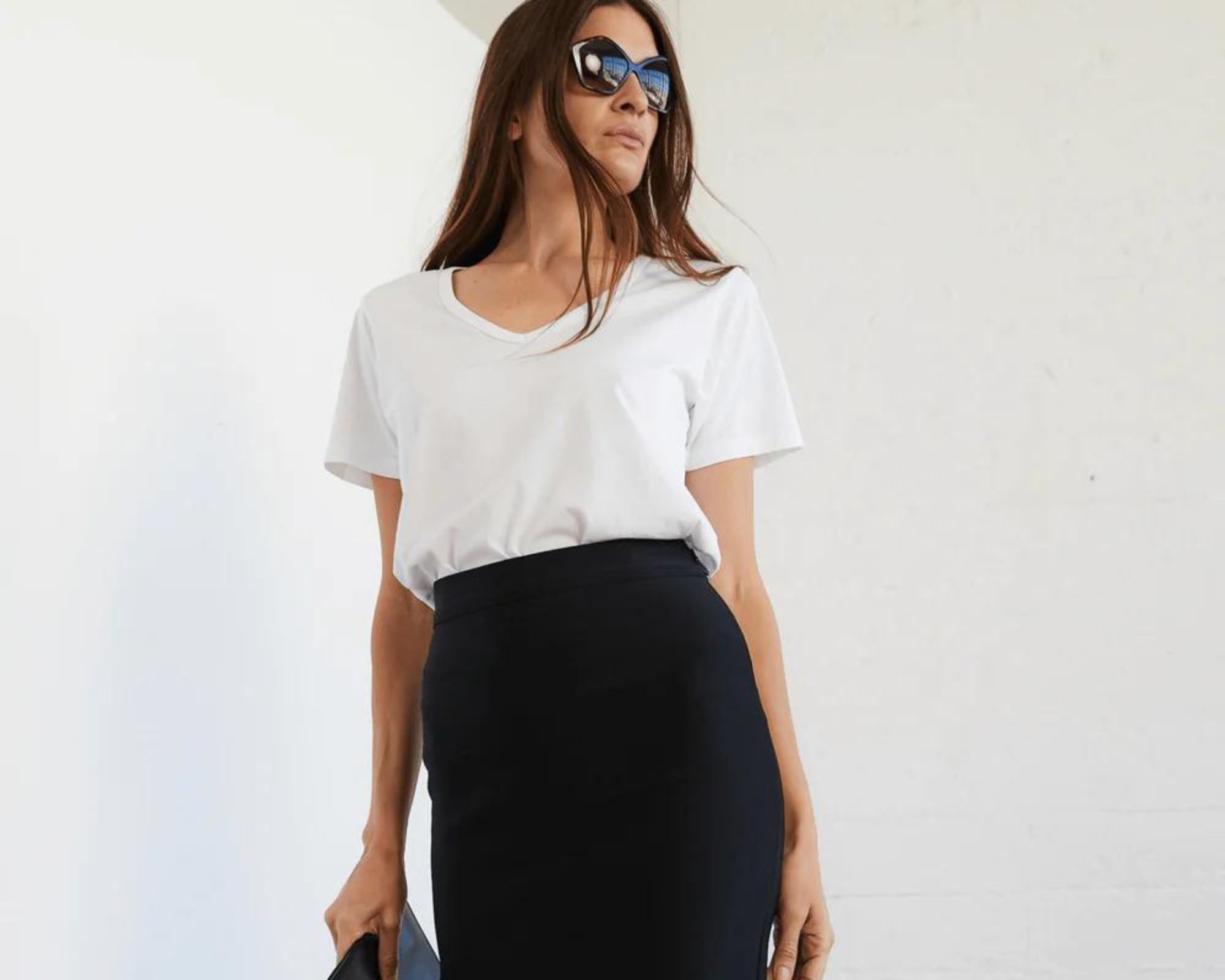 A business look pairing a deep v-neck white organic cotton tee by The Classic T-Shirt Company with a black pencil skirt and clutch.