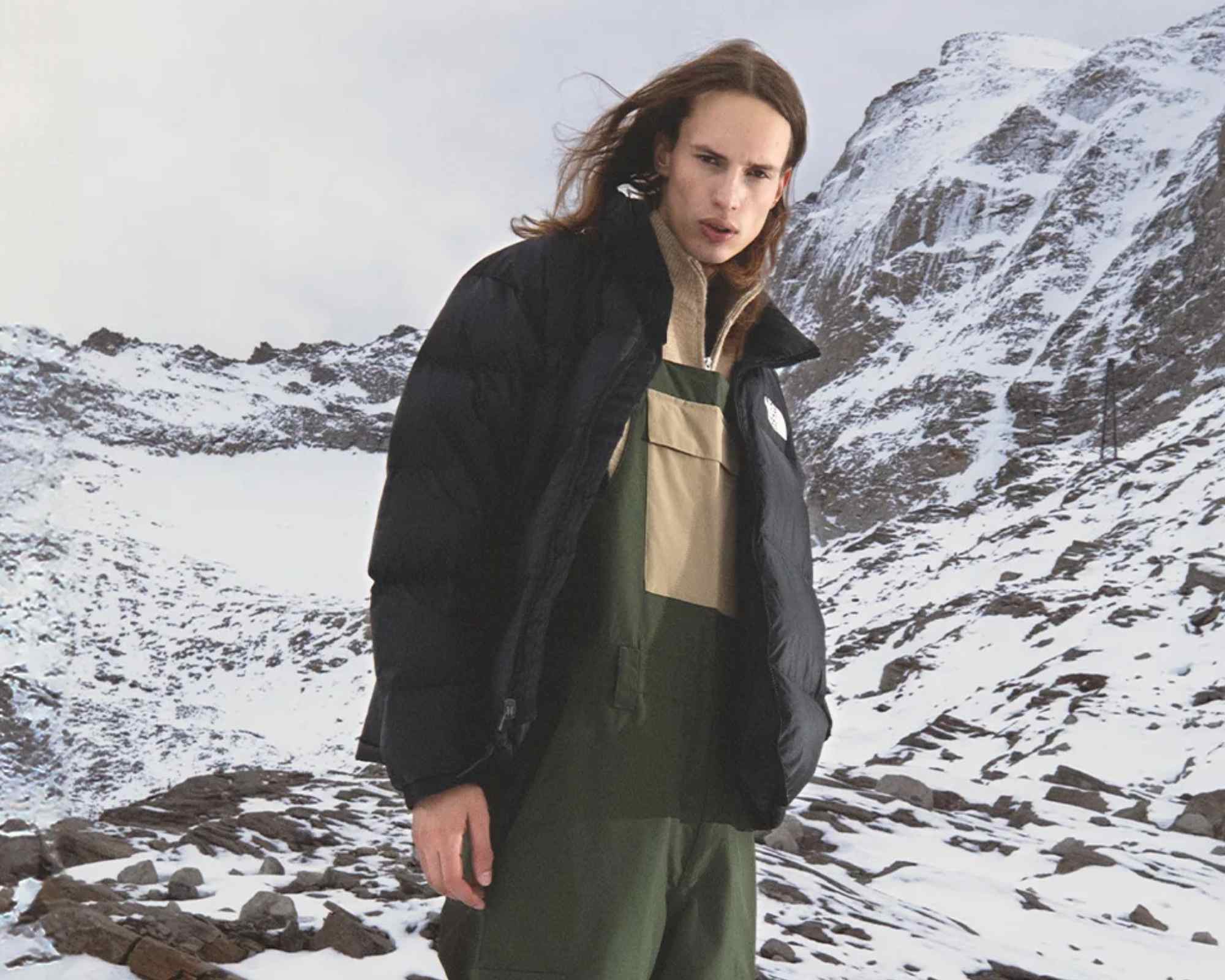 person in snowy mountains wearing winter clothes