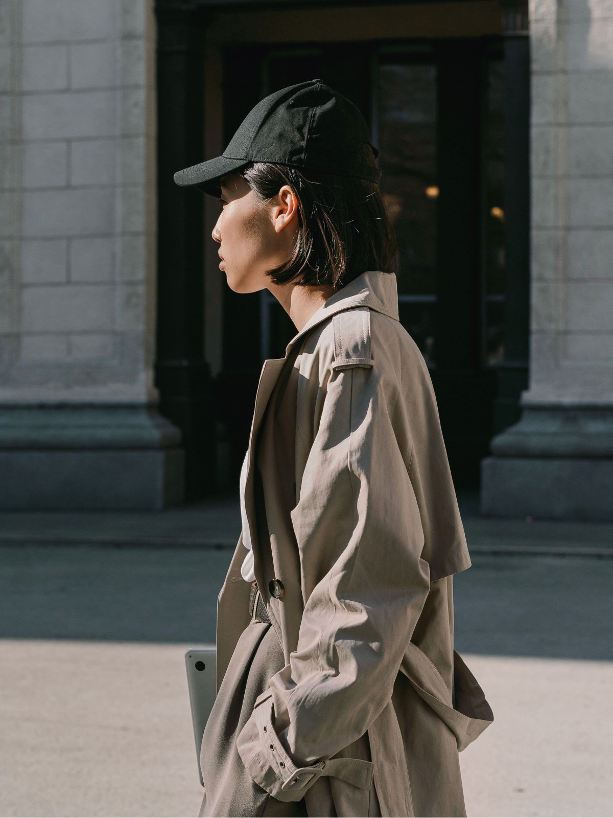 person wearing baseball cap and trench coat