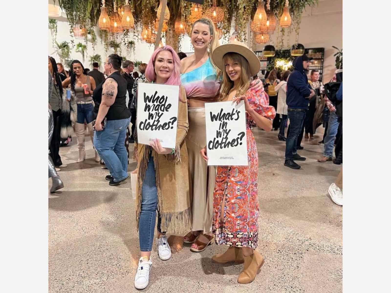 People holding up Fashion Revolution signs