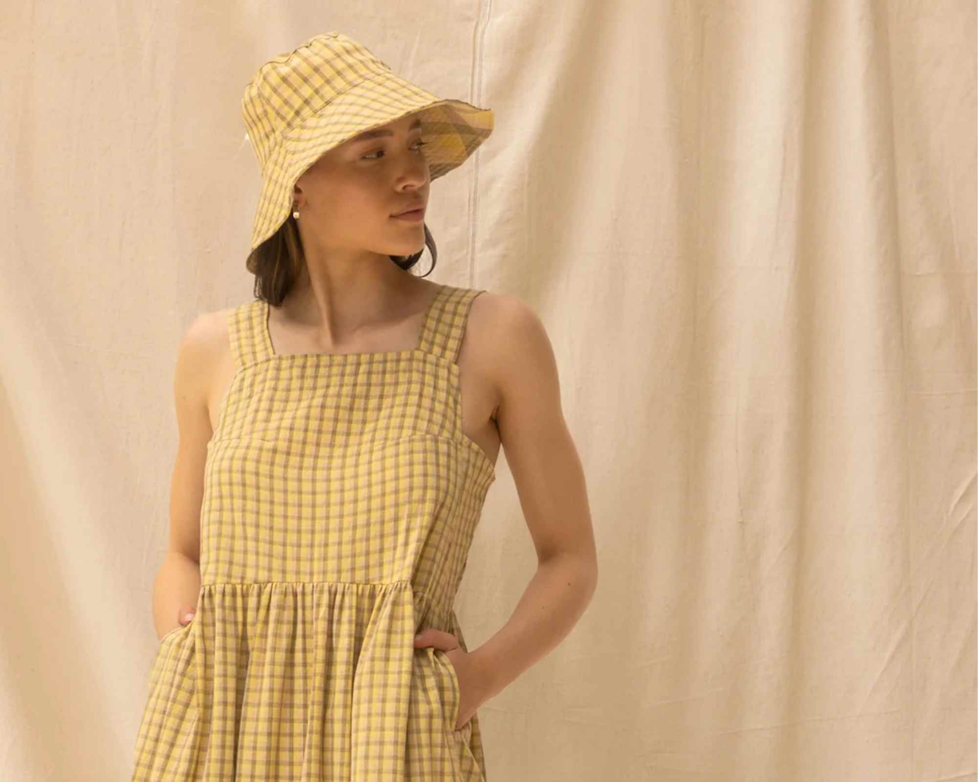 Woman wearing yellow checked dress and hat