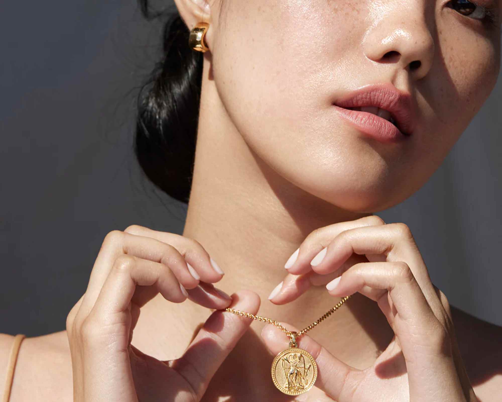 person wearing gold necklace from futura jewelry