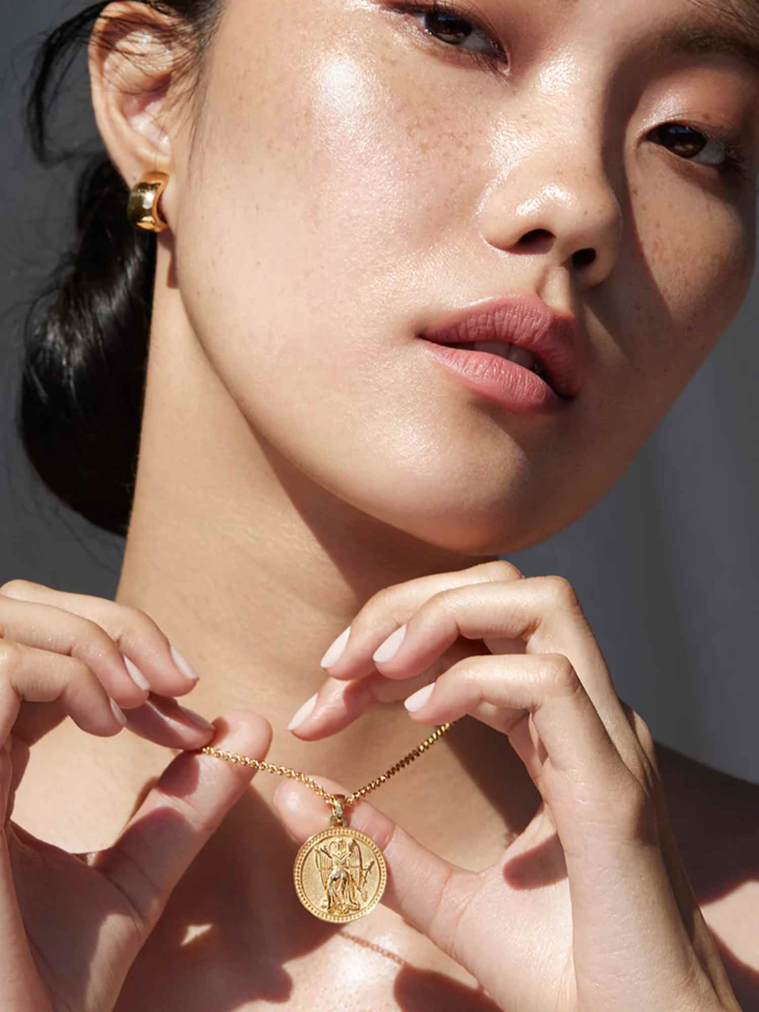 person wearing gold necklace from futura jewelry