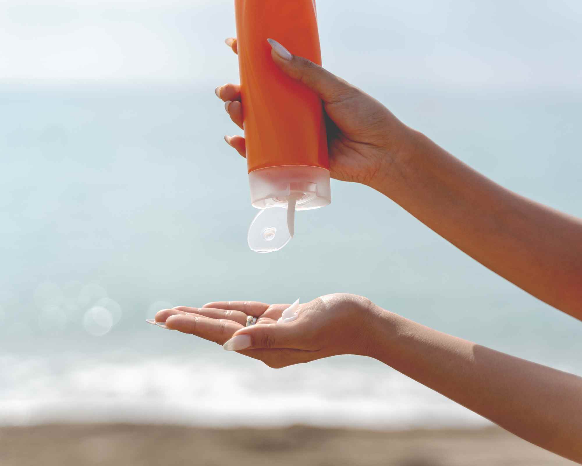 Person squeezing sunscreen into hand