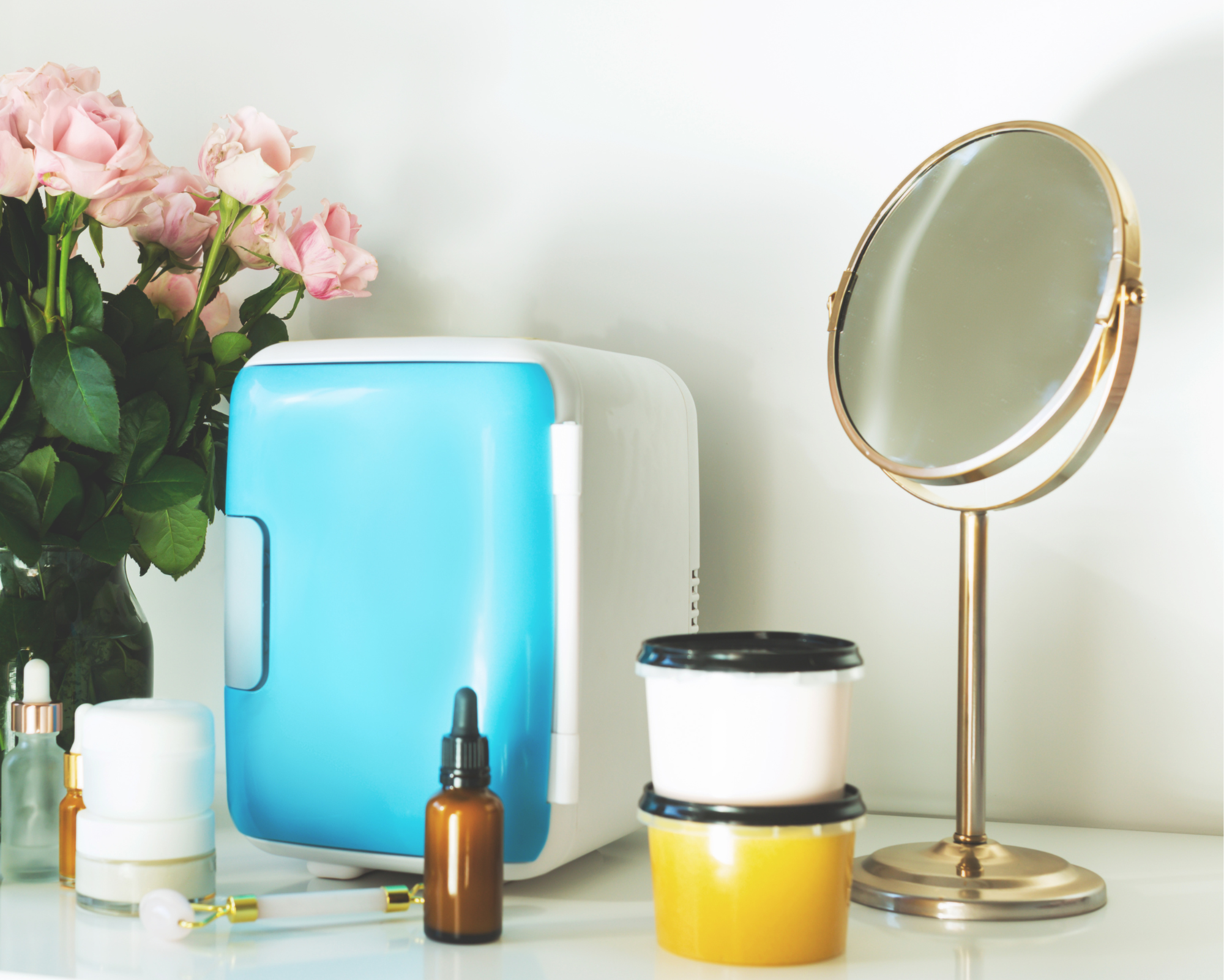 Among a range of beauty products and a mirror sits a minifridge storing skincare products.