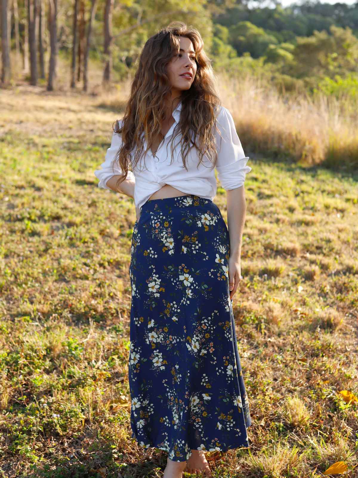 person wearing floral print skirt in a field