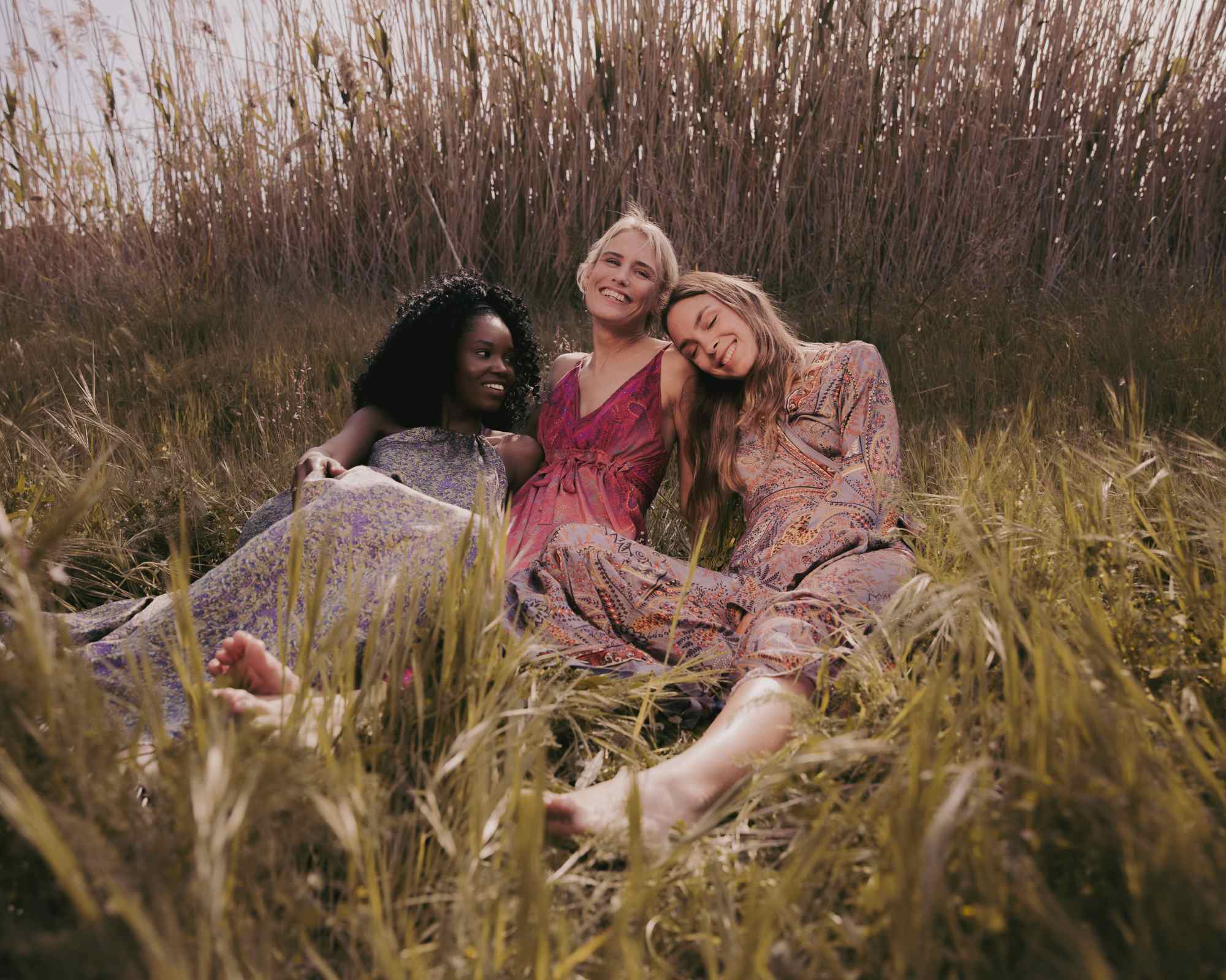 women in a field smiling