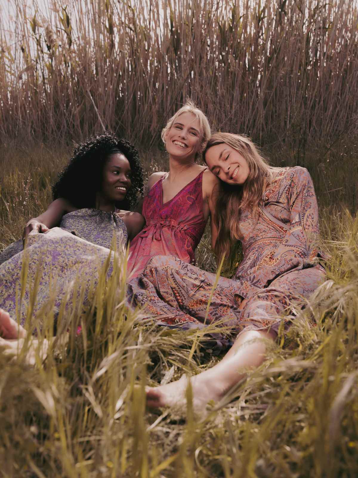 women in a field smiling