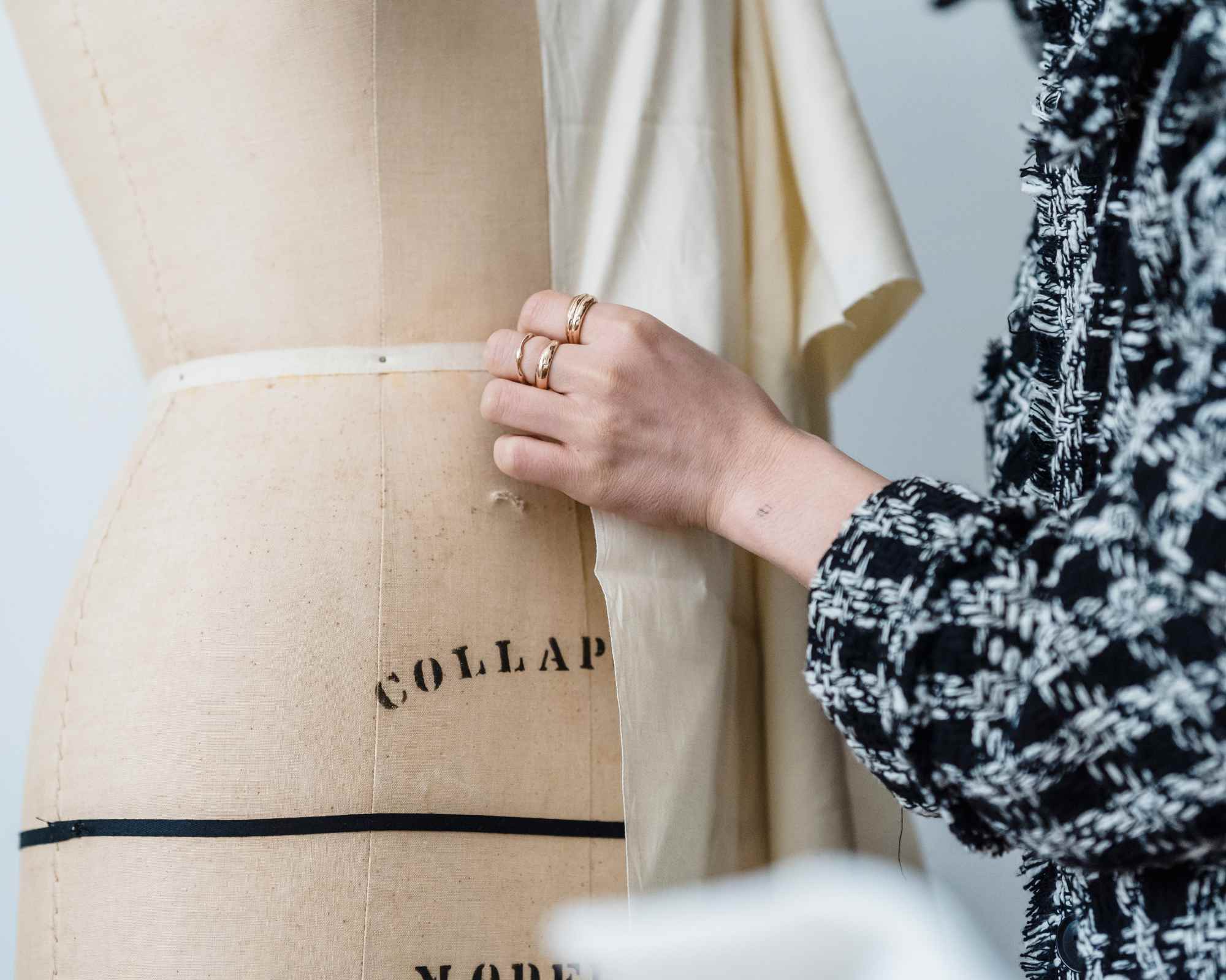 person touching dressmaker's mannequin