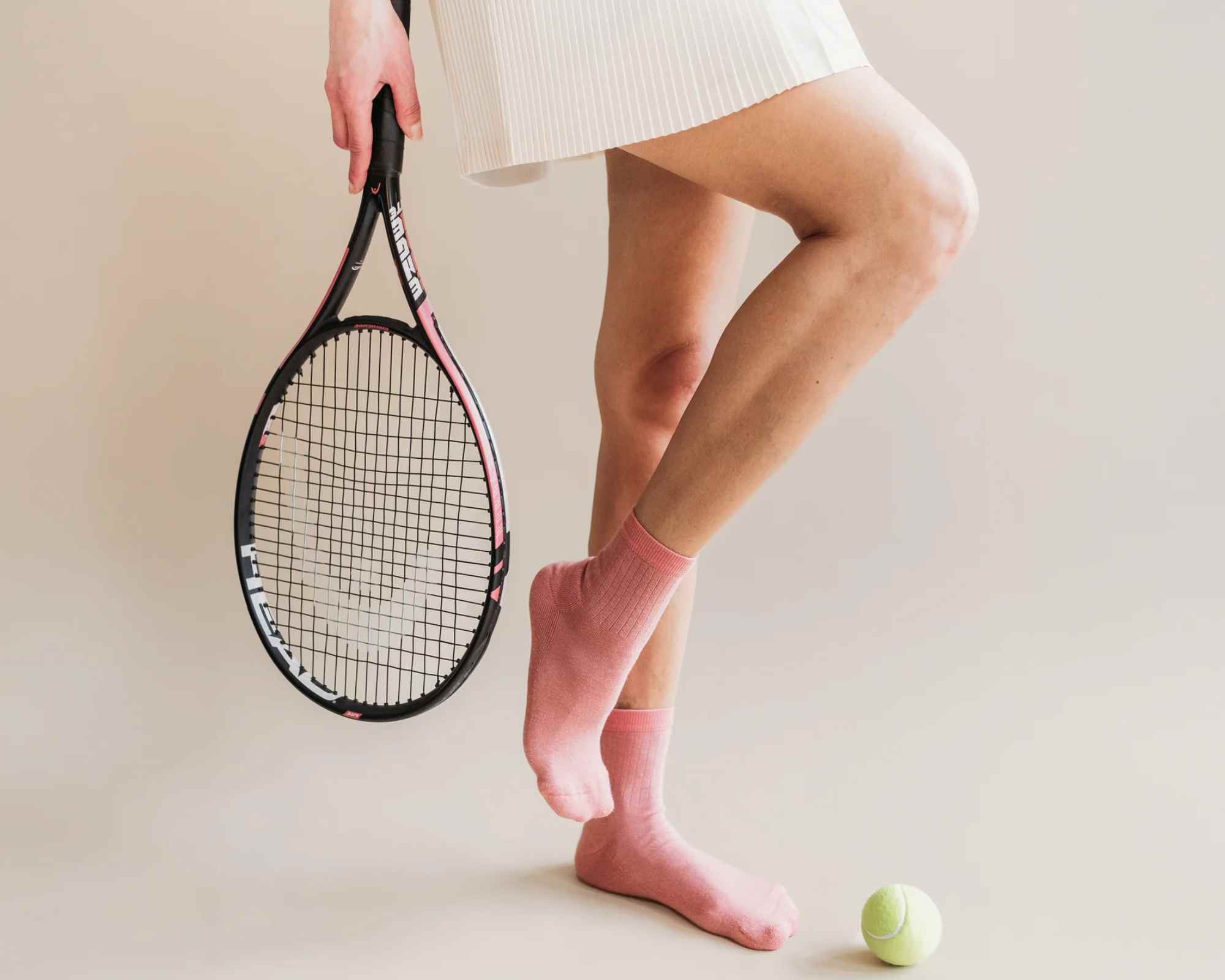 person wearing tennis skirt and holding racket