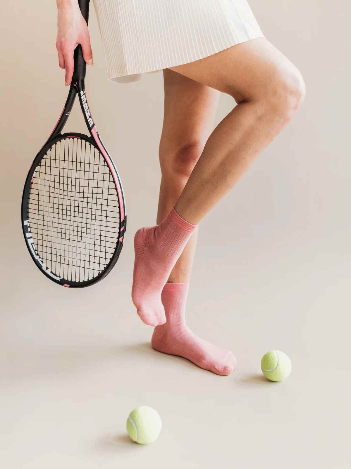 person wearing tennis skirt and holding racket