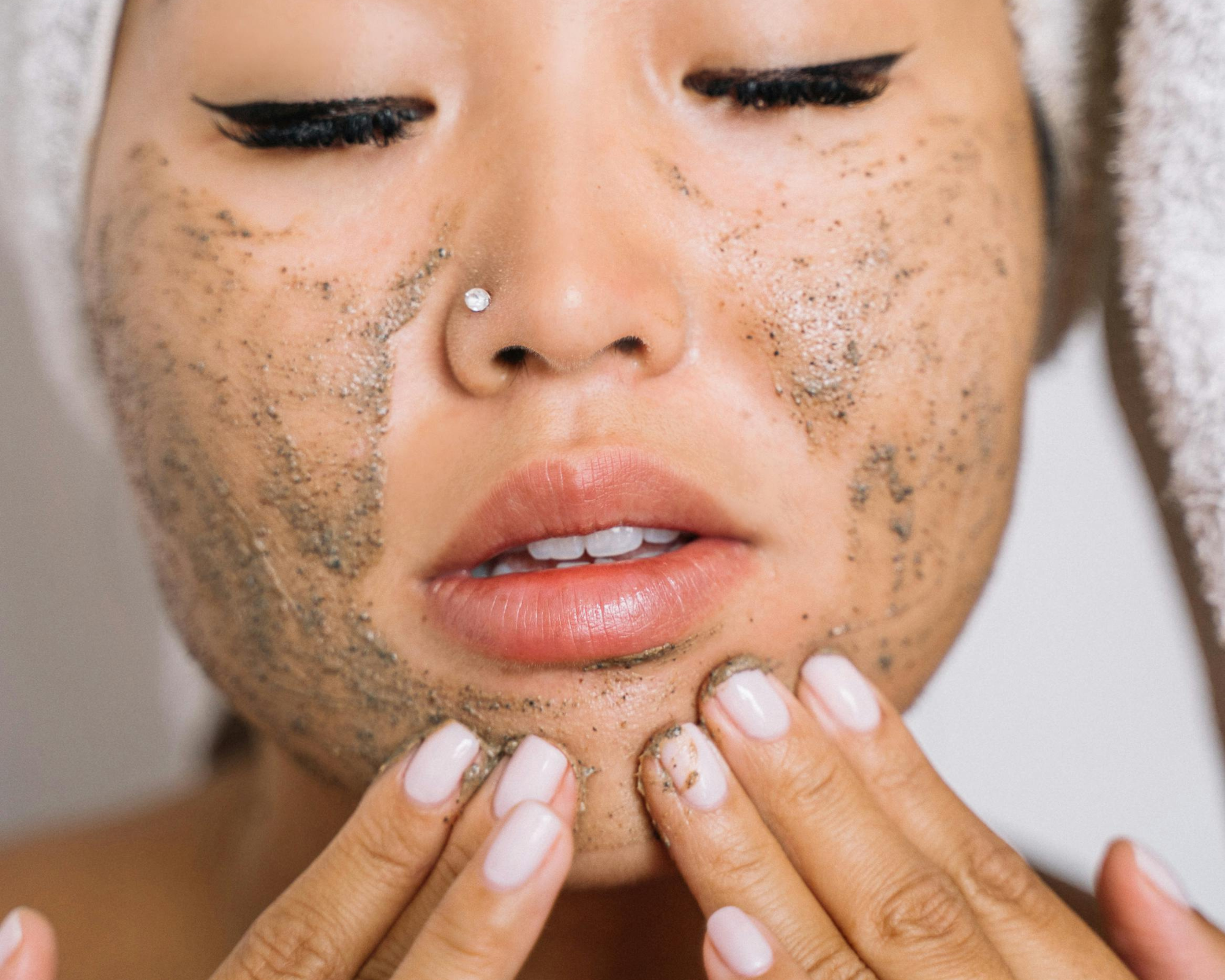 person rubbing exfoliant on their face