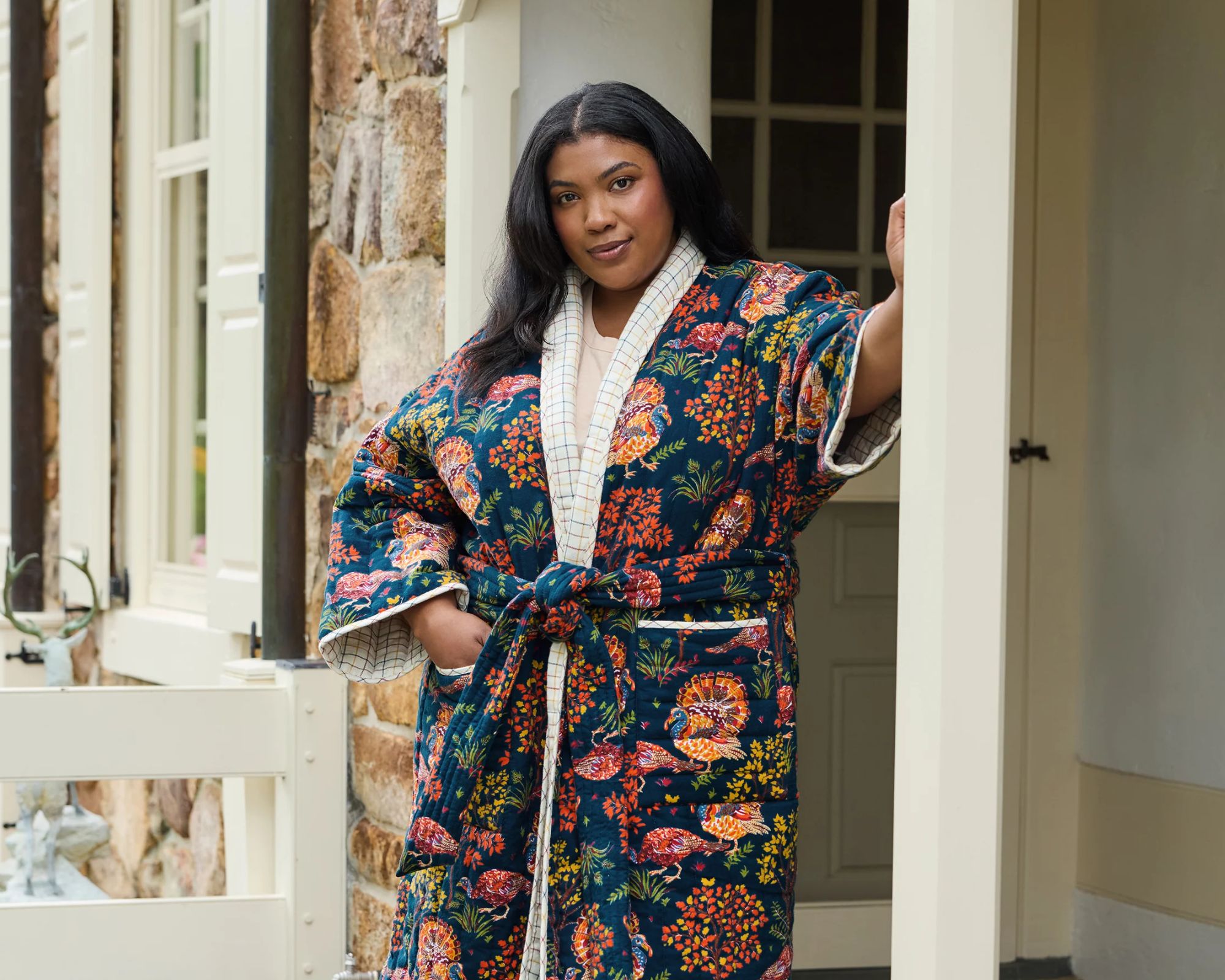 person standing on a porch wearing a printed robe