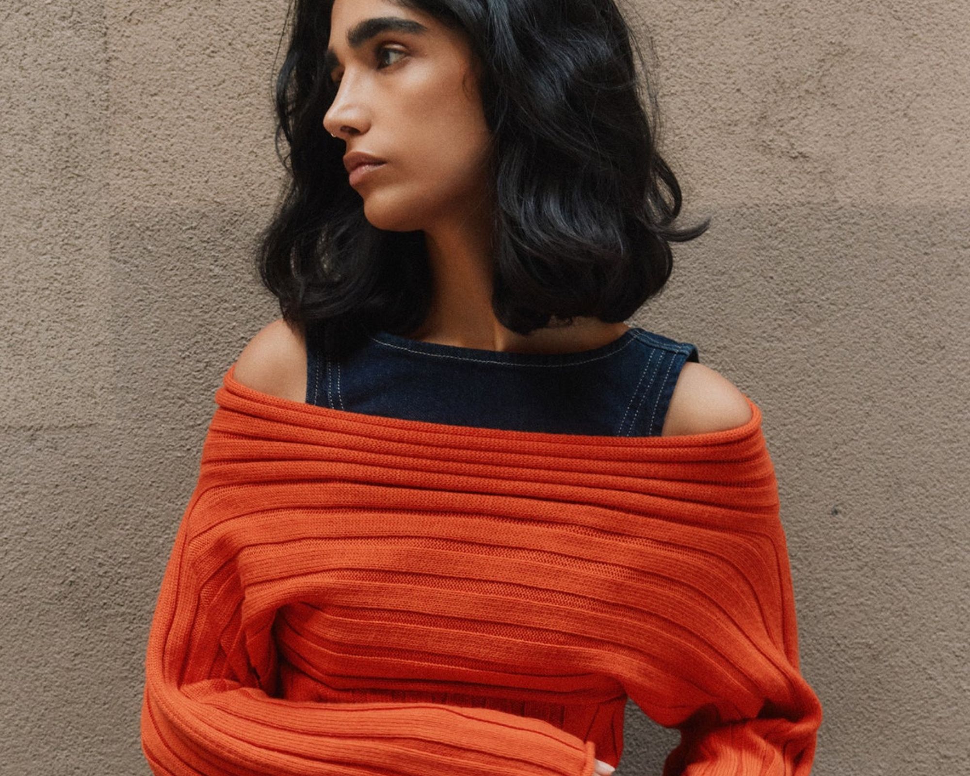 person wearing orange more sustainable off-shoulder sweater from kotn
