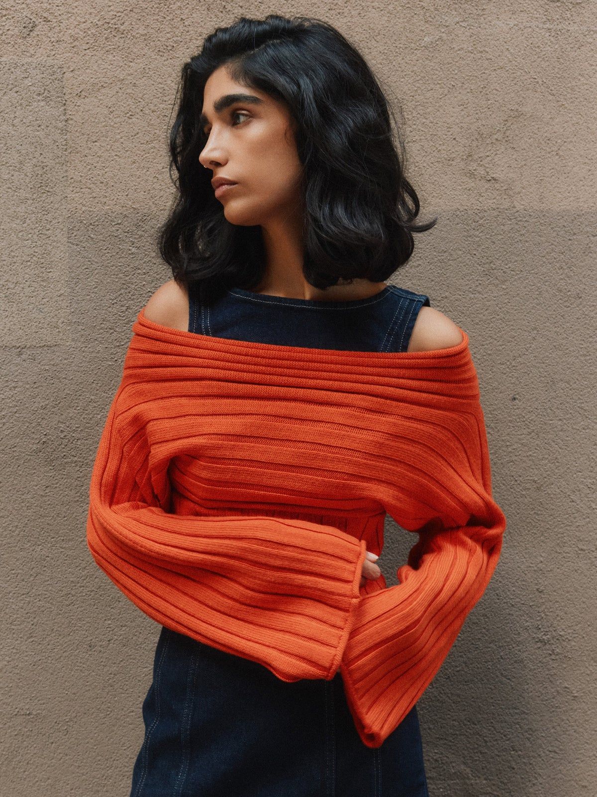 person wearing orange more sustainable off-shoulder sweater