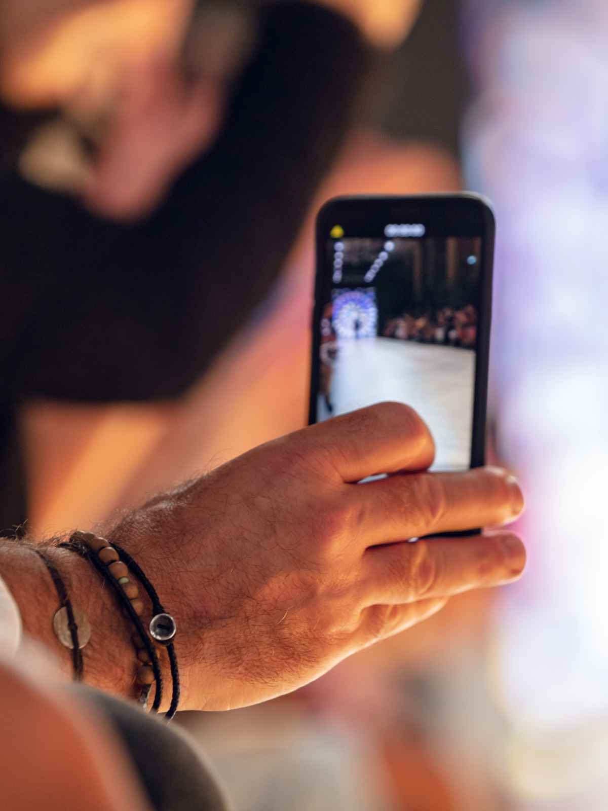 person filming a fashion runway