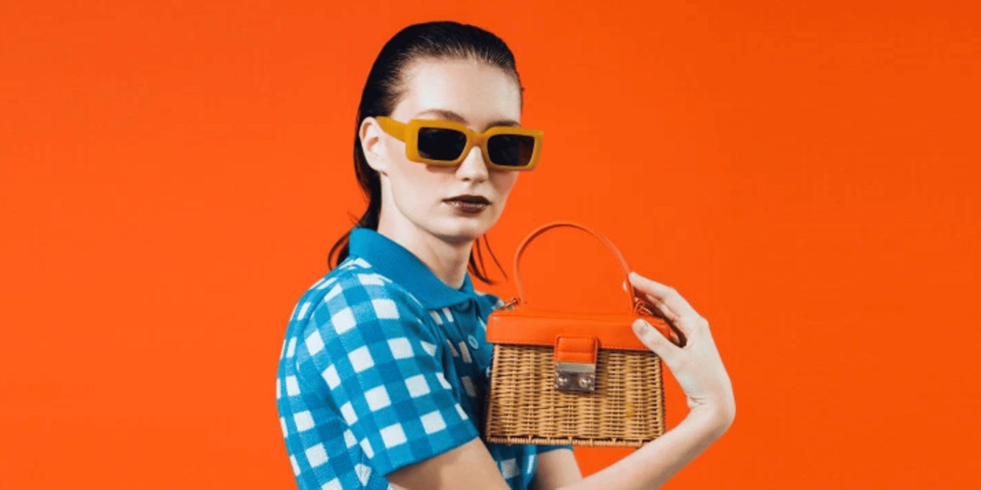 person holding wicker bag showing ebay's preloved fashion offering
